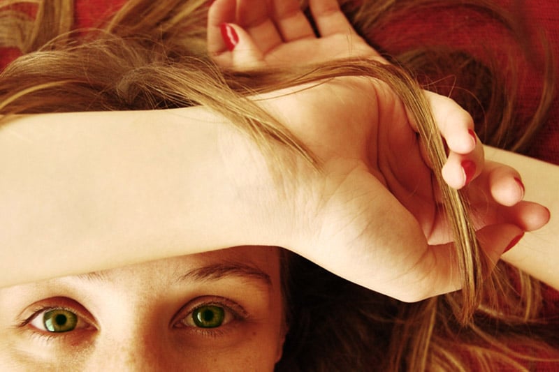 Girl with arm over forehead