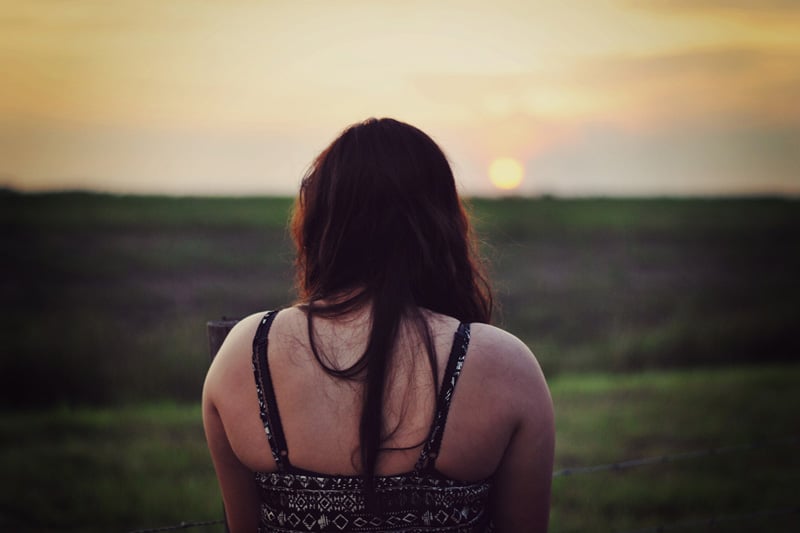 Girl in bright light, standing on field