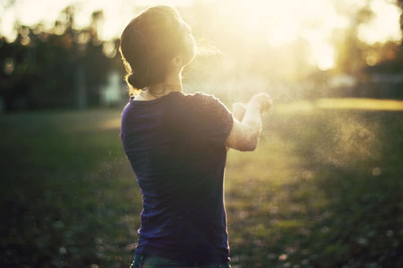 Girl in bright light, standing on field