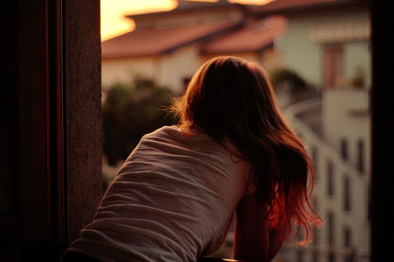 Girl at window, looking out