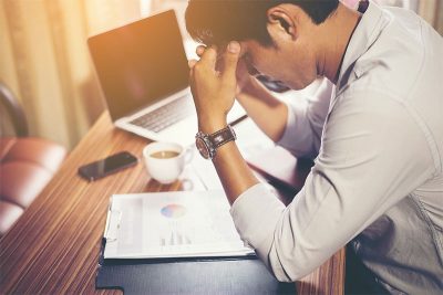 Man feeling stressed at his work desk: Dealing with Digital Burnout