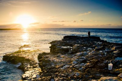 Man at the sea, looking at sunrise