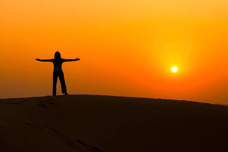 Silhouette of a woman facing the sunrise