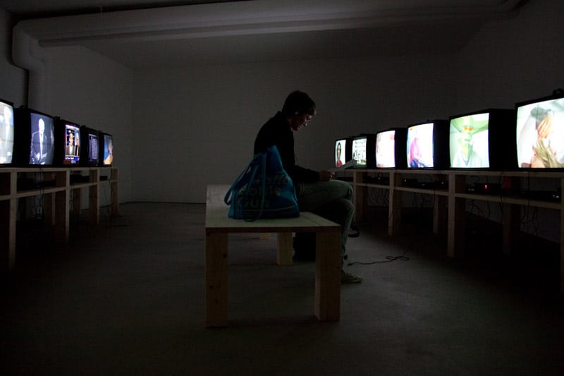 Unhappy person, sitting in a room with television sets